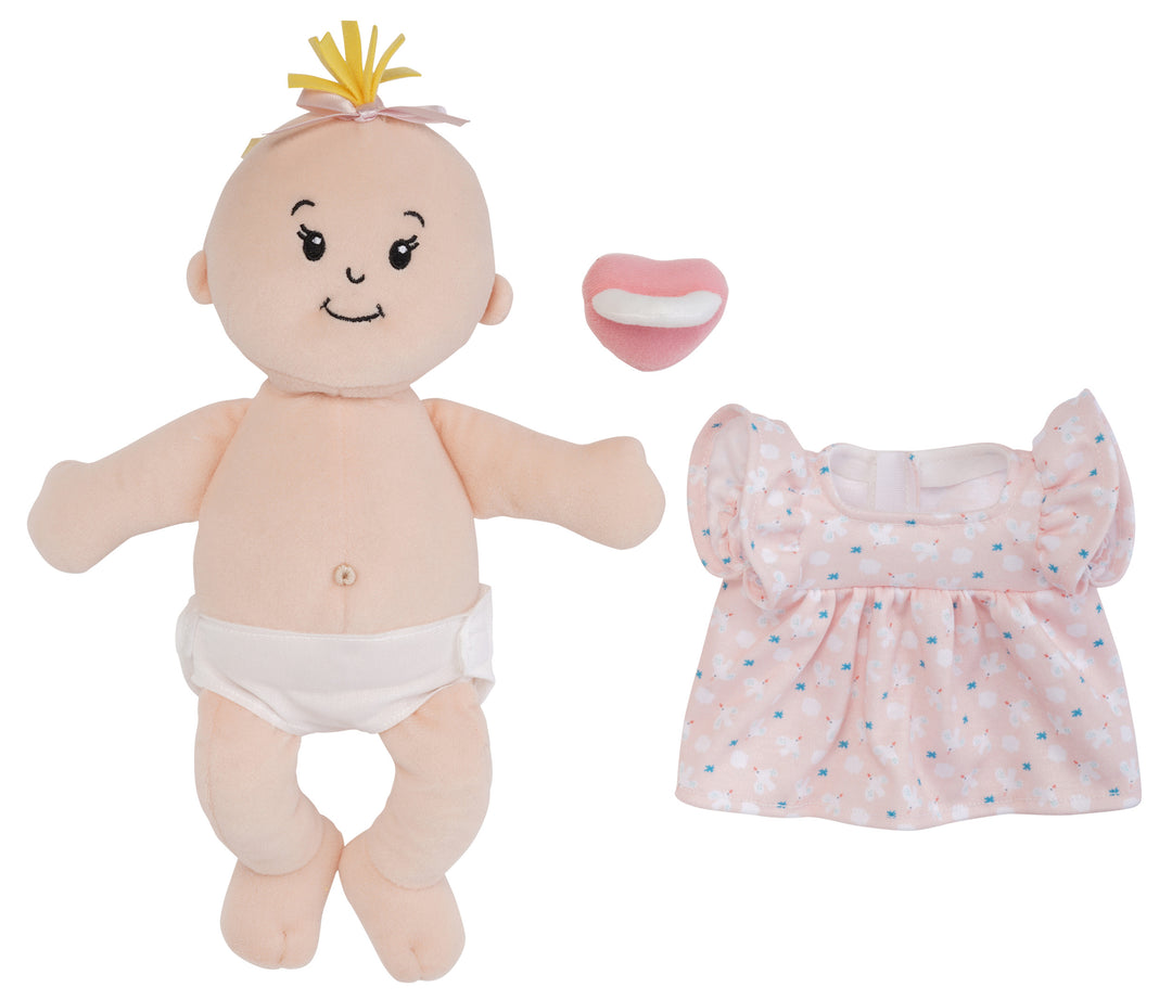 peach skinned soft baby doll with blonde hair tuft and outfit removed and magnetic pacifier off to the side of the doll to show the fabric belly button and removable fabric diaper on the doll.