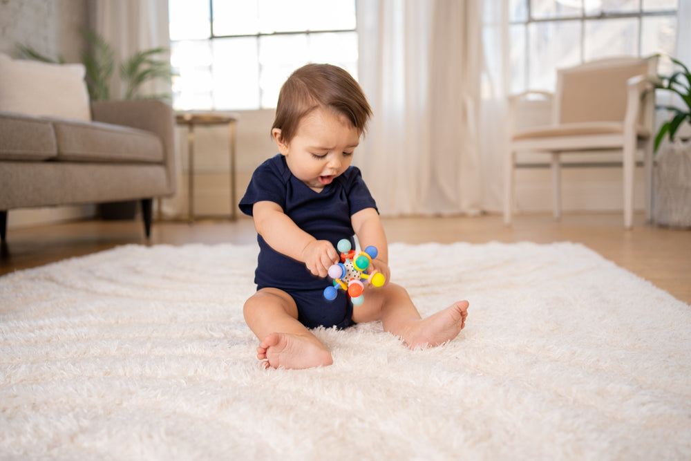 baby holding atom teether