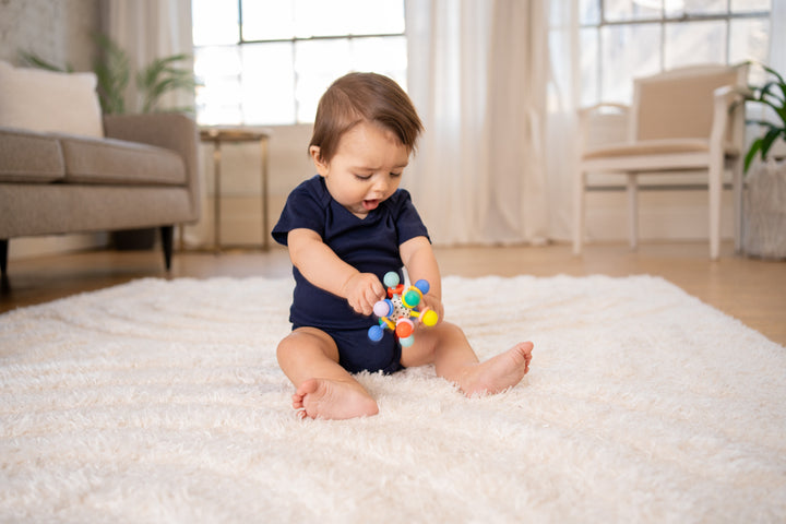 baby holding atom teether