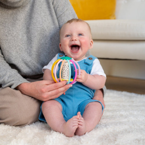 happy baby playing with a colorful toy ball
