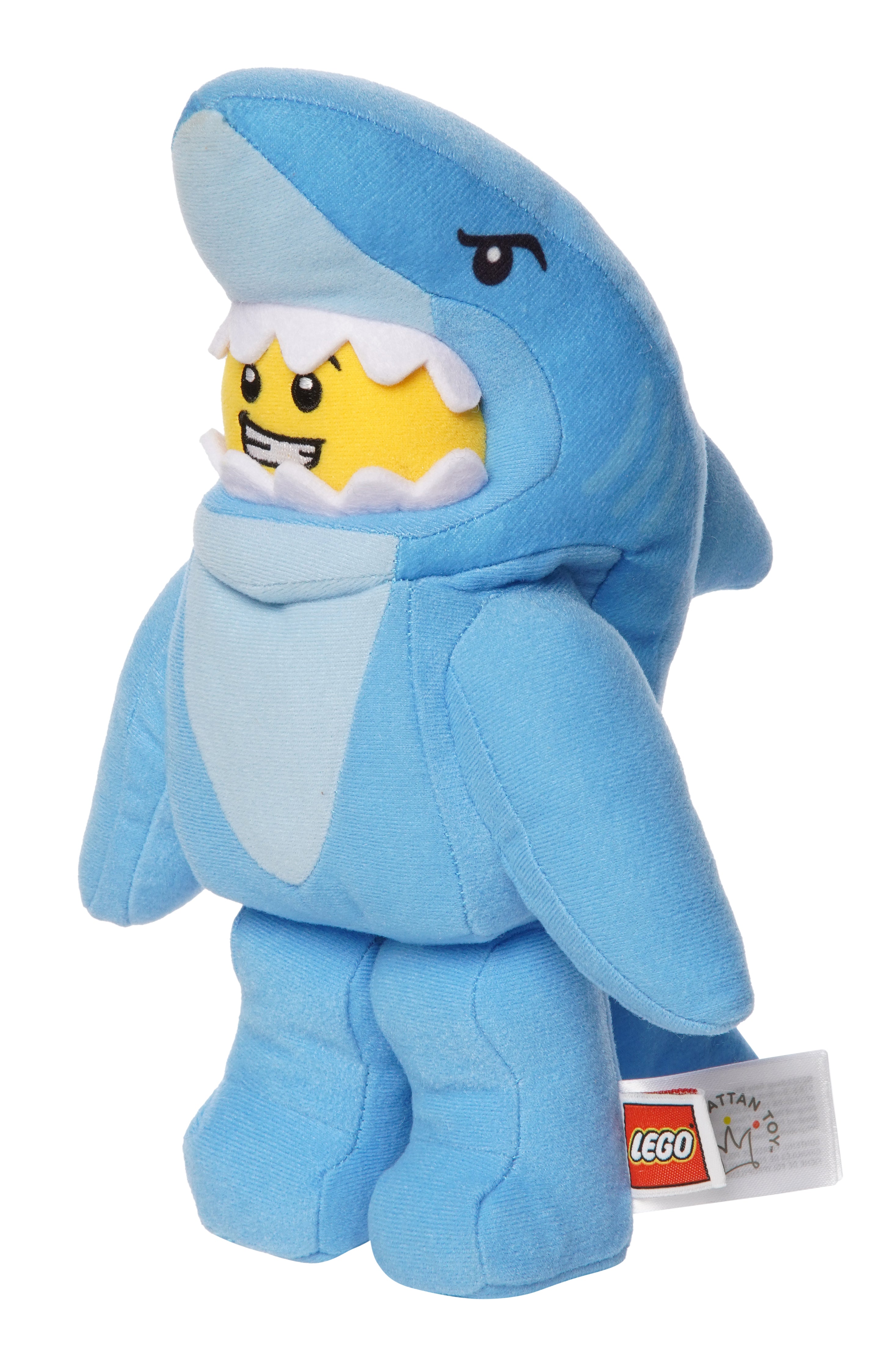 Light blue shark costume plush inspired by LEGO shown in three quarter view with a grinning yellow face inside the shark hood.
