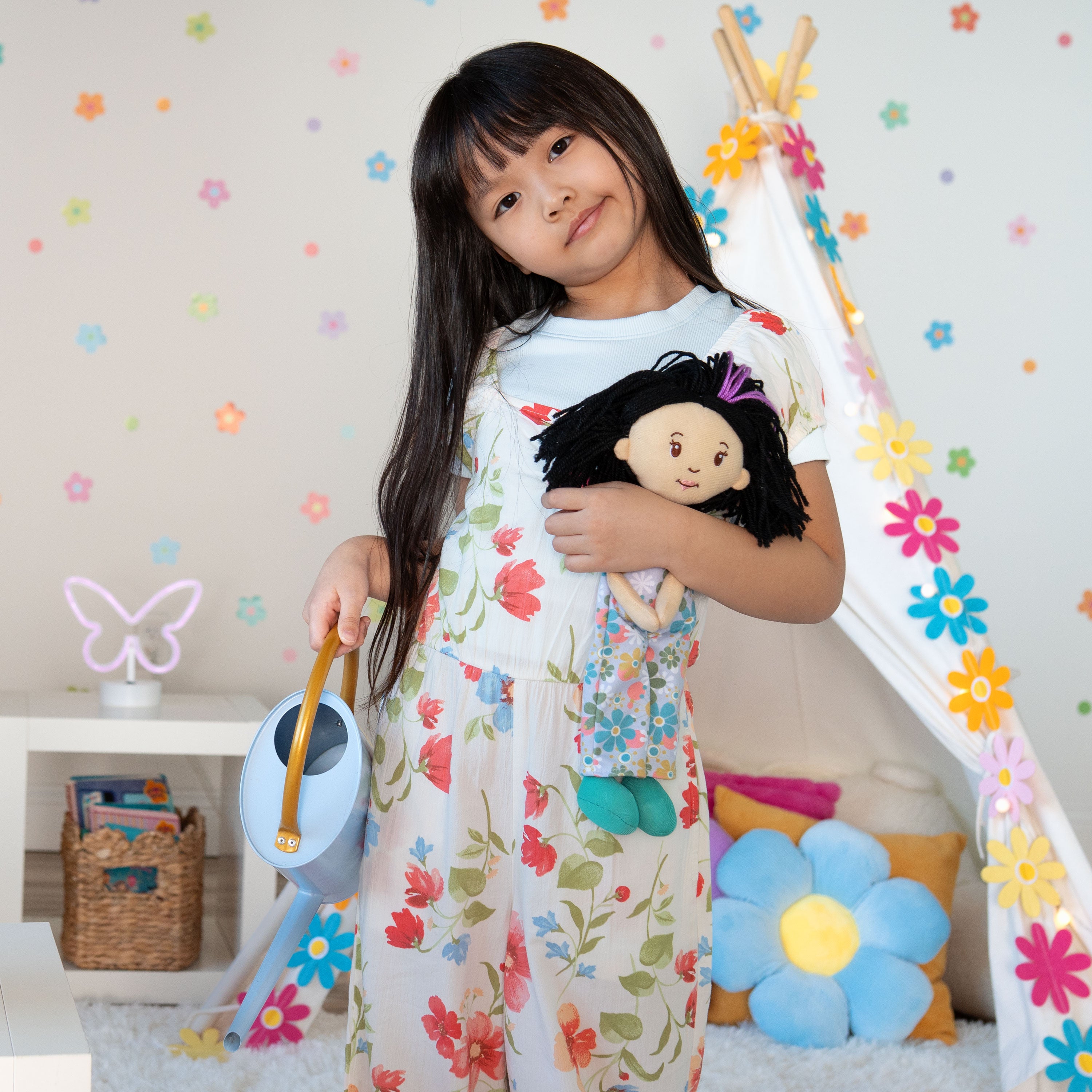 Girl holding Groovy Girls Daisy doll and watering can