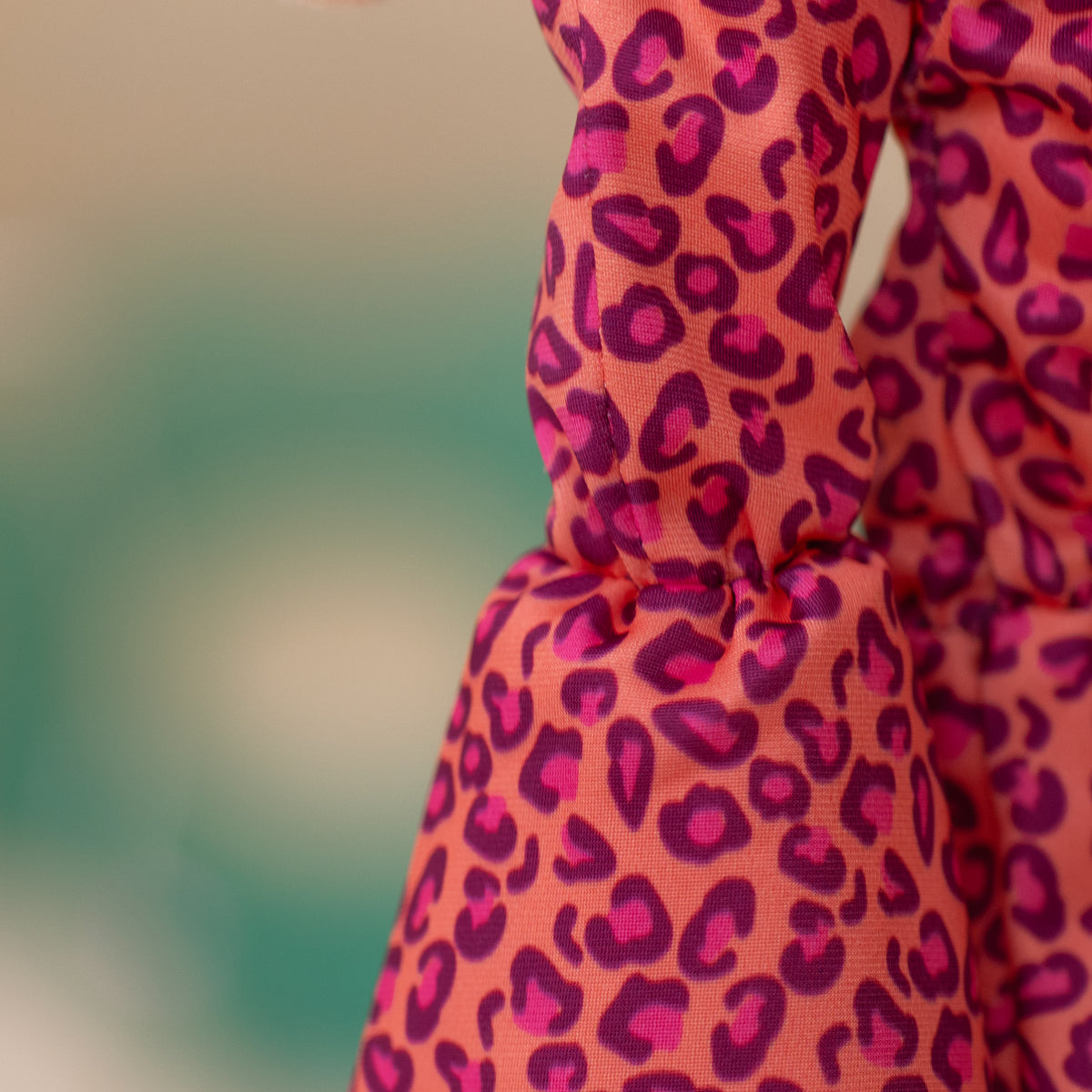 close up of soft doll flare pants that are pink, purple, and orange animal print