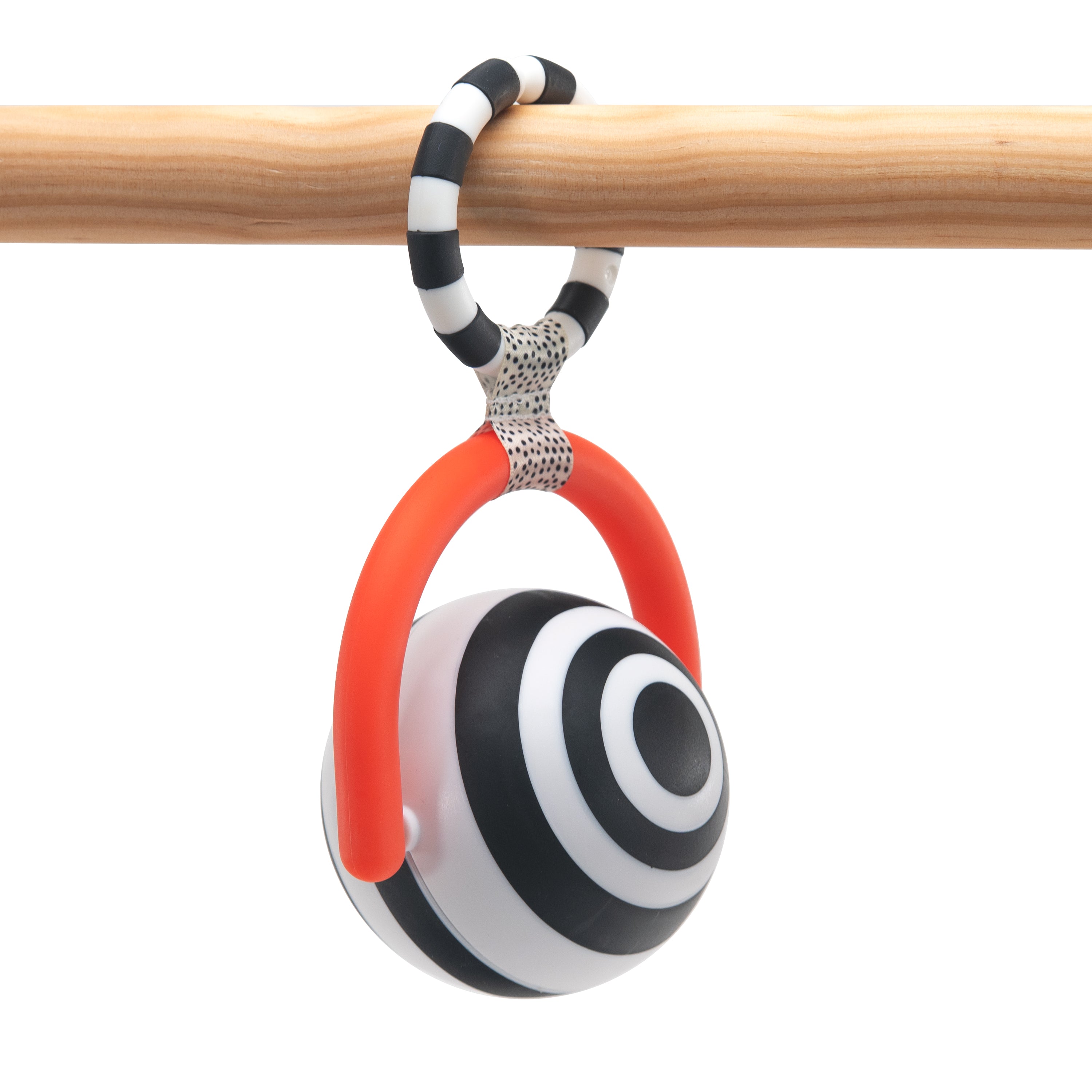 Black and white striped bullseye rattle toy with red accents against a white background