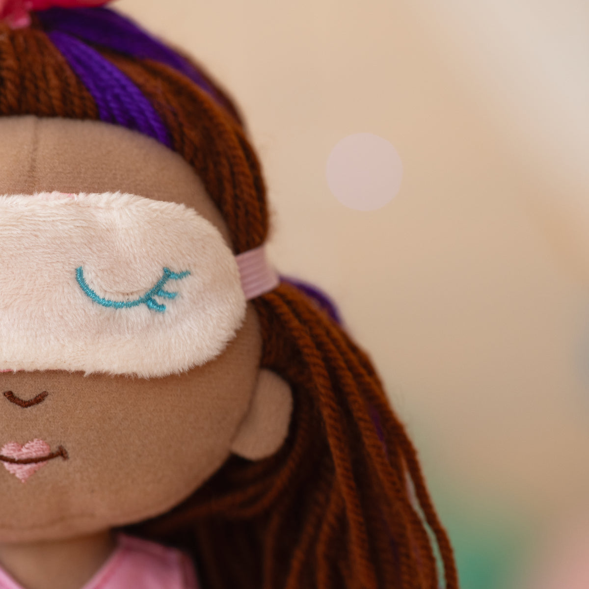 close up of doll wearing a sleeping mask over her eyes