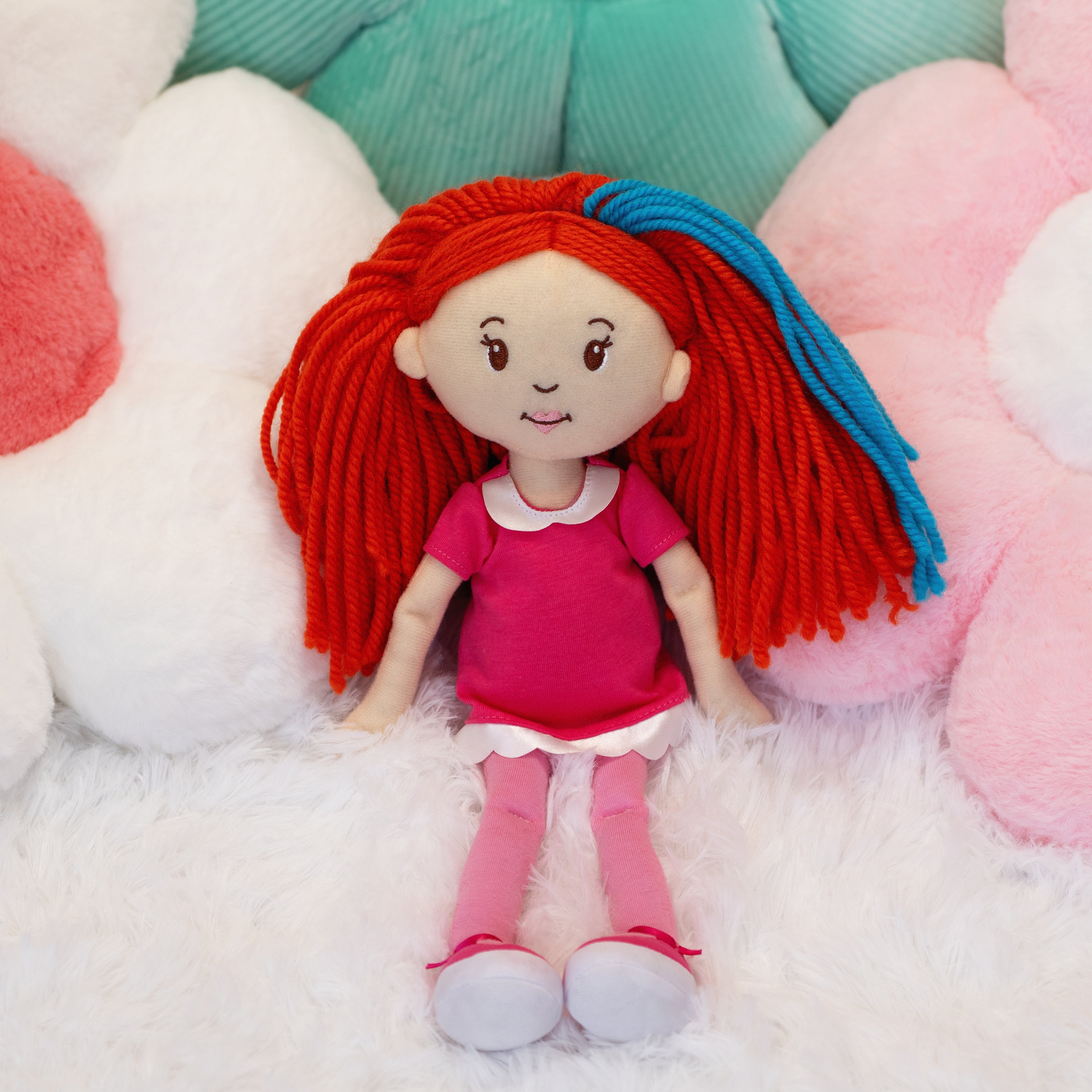 Groovy Girls Poppy doll leaning against flower shaped pillows