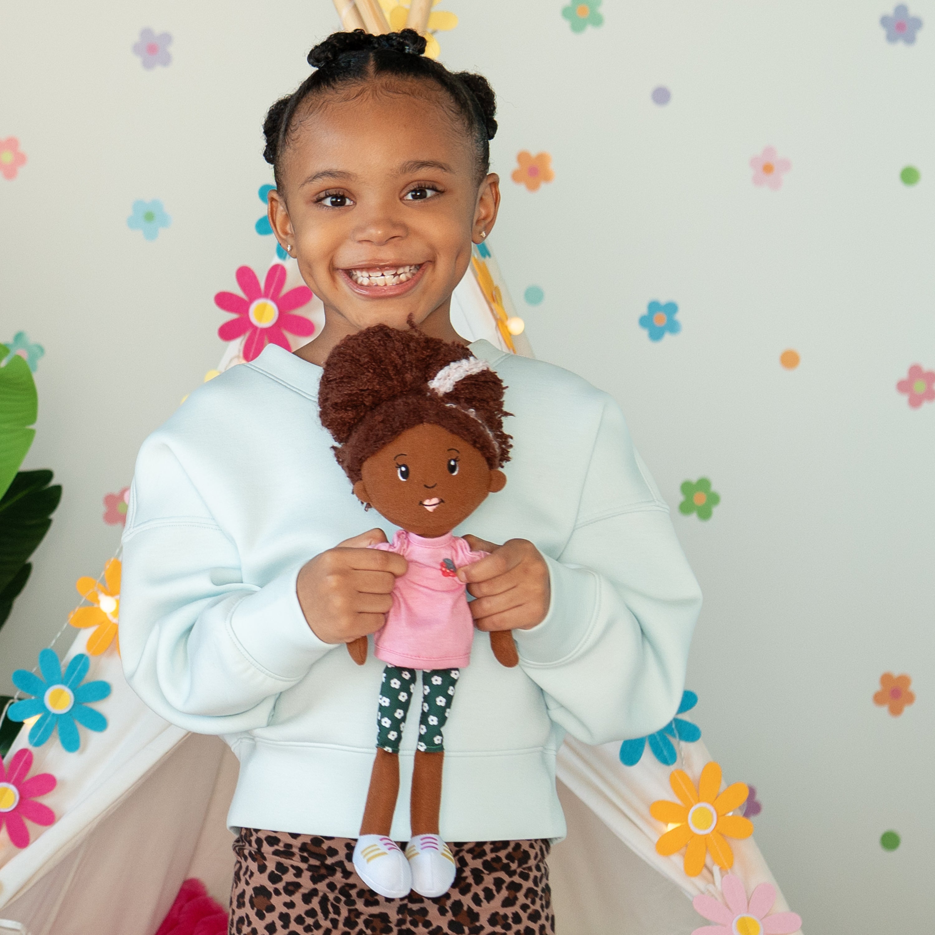Girl holding Groovy Girl Saige doll, smiling