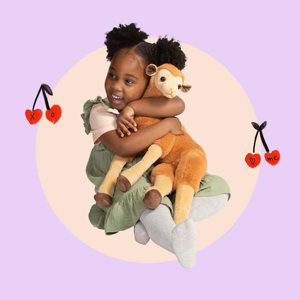 African American girl hugging a cozy plush exotic deer with floating heart cherries in the background