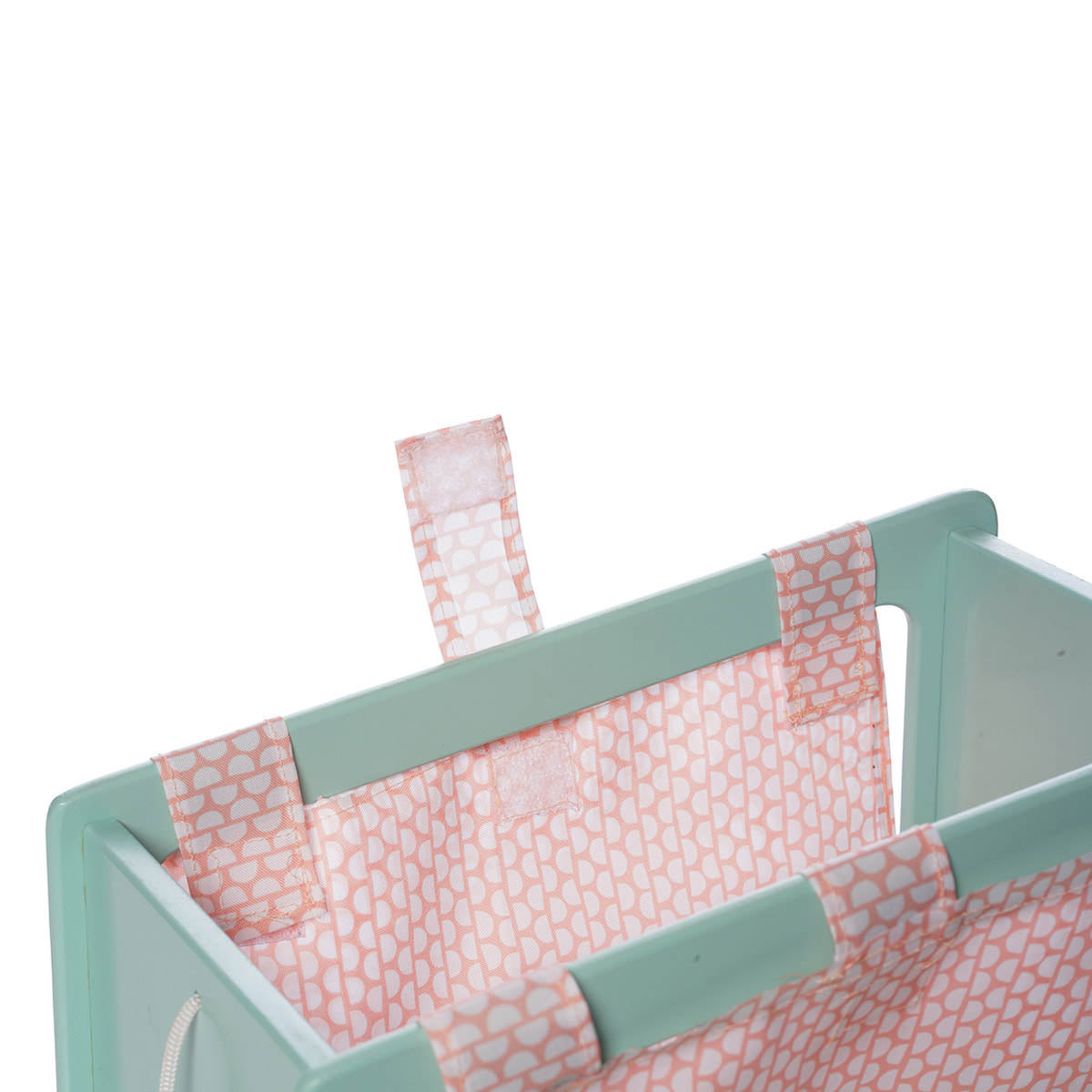 A close up of the velcro removable fabric insert for the blue and pink wooden doll wagon.