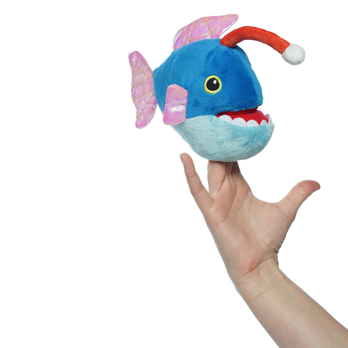 Angled view of a hand inside a plush blue angler fish puppet with pink fins, a red and white angler lure, and yellow eyes.