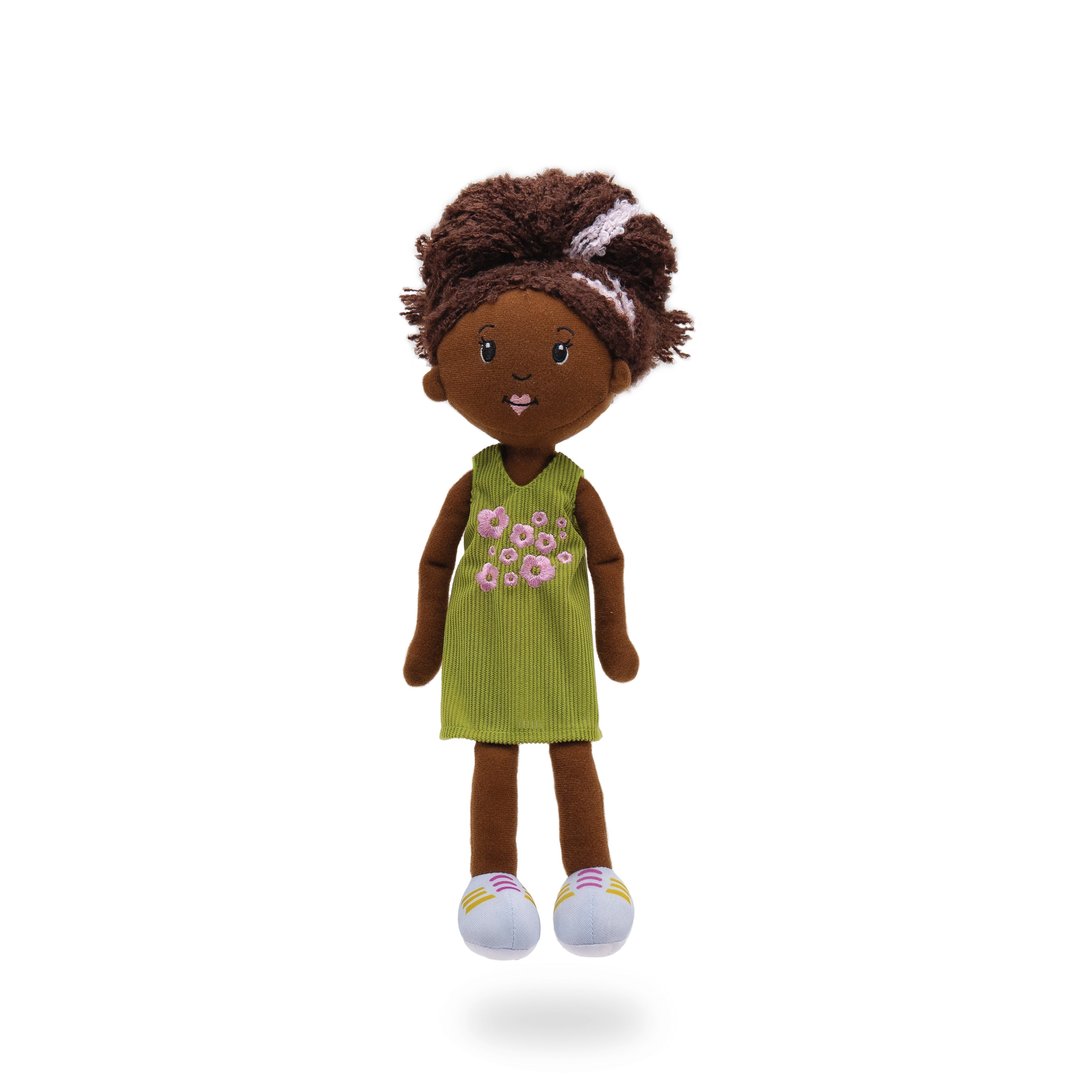 Soft doll wearing green corduroy dress with pink embroidered flowers.
