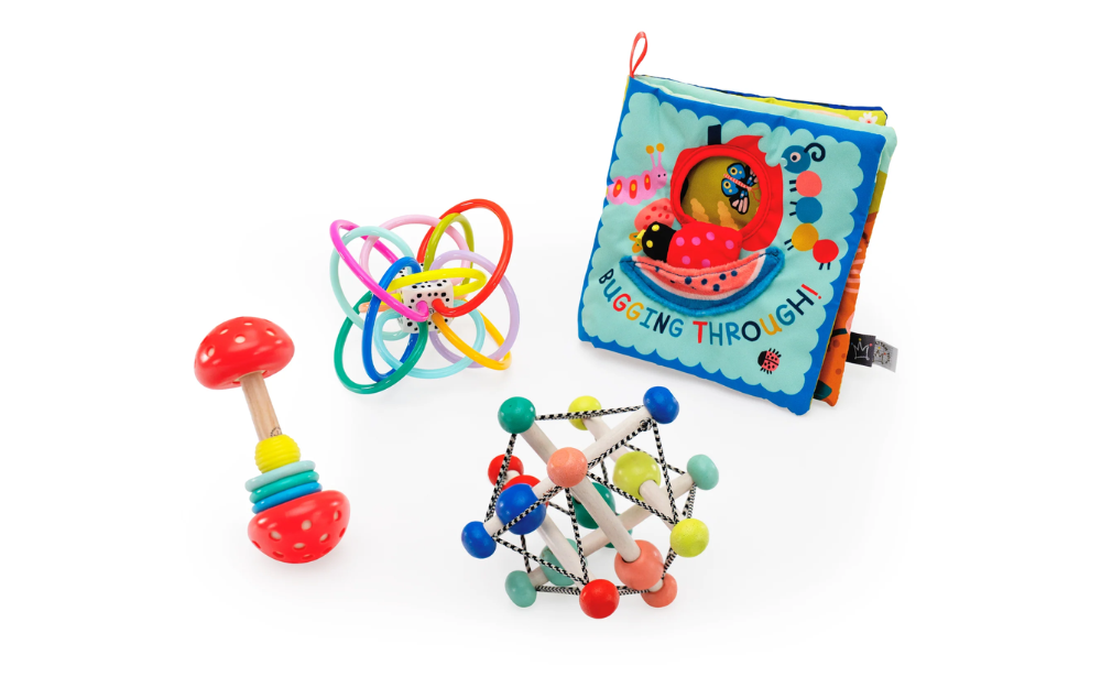 Set of colorful baby toys including a rattle, ball, and soft book on a white background