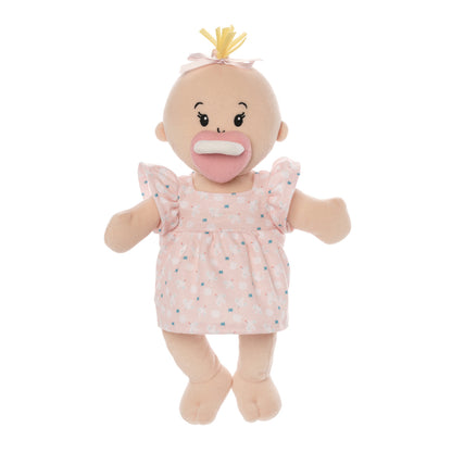 soft baby doll with peach skin and a blonde hair tuft in a dress standing with magnetic pacifier attached to the face
