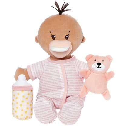Plush baby doll with pink outfit, bottle, and teddy bear on a white background
