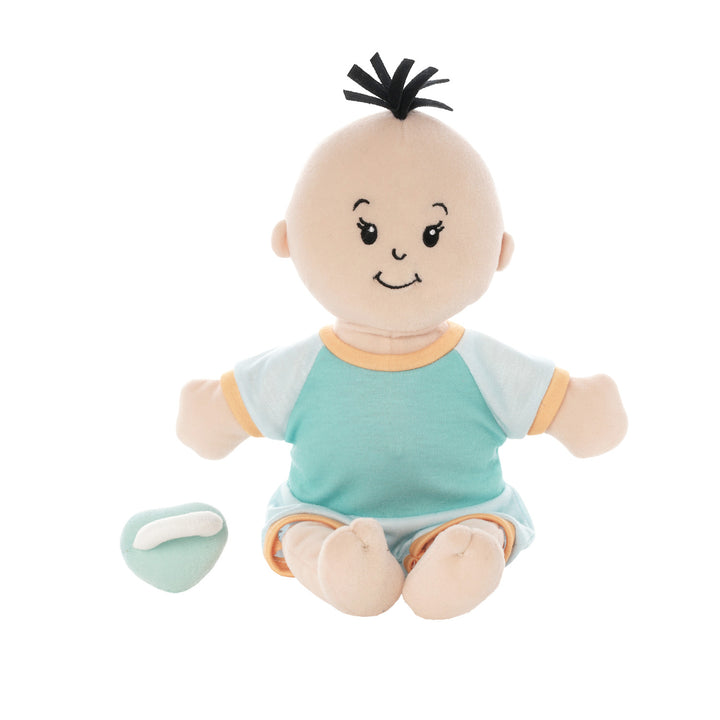 soft baby doll with peach skin and black hair tuft in a short sleeve and shorts outfit seated with a blue magnetic pacifier off to the side