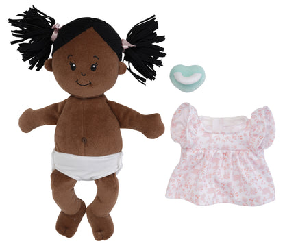 brown skinned soft baby doll with outfit removed and magnetic pacifier off to side of doll to show the fabric belly button and removable fabric diaper on the doll.