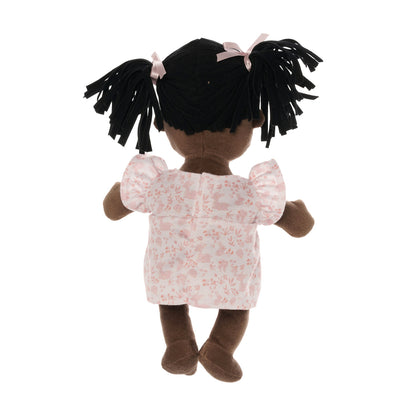 backside of brown skinned baby doll with black pigtails wearing a pink dress.