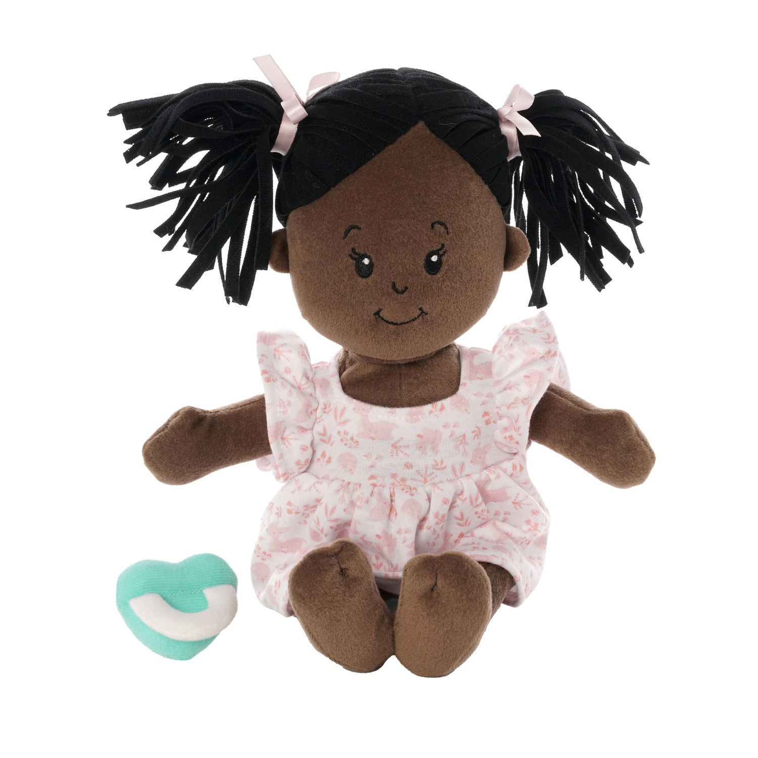 brown skinned soft baby doll with black pigtails in a pink dress with a blue magnetic pacifier seated off to side