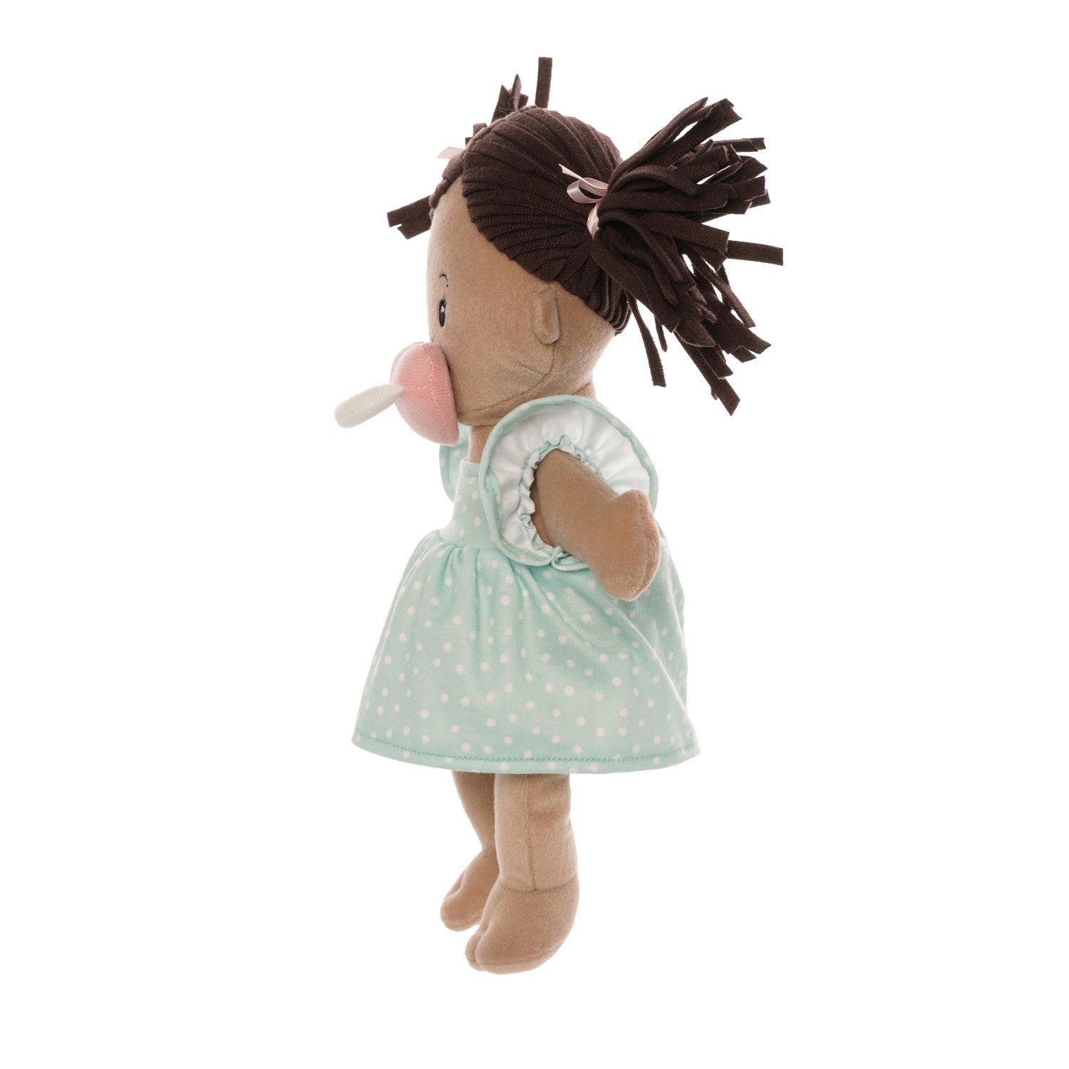 soft baby doll with beige skin and brown pigtails wearing a dress with a magnetic pacifier
