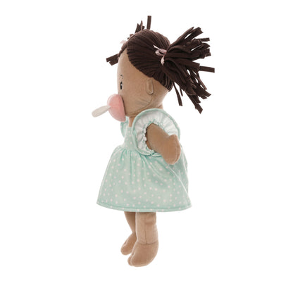 soft baby doll with beige skin and brown pigtails wearing a dress with a magnetic pacifier