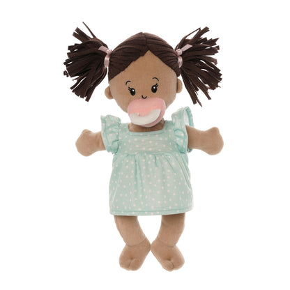 standing beige soft baby doll with brown pigtails in blue dress seated with pink magnetic pacifier attached to the face