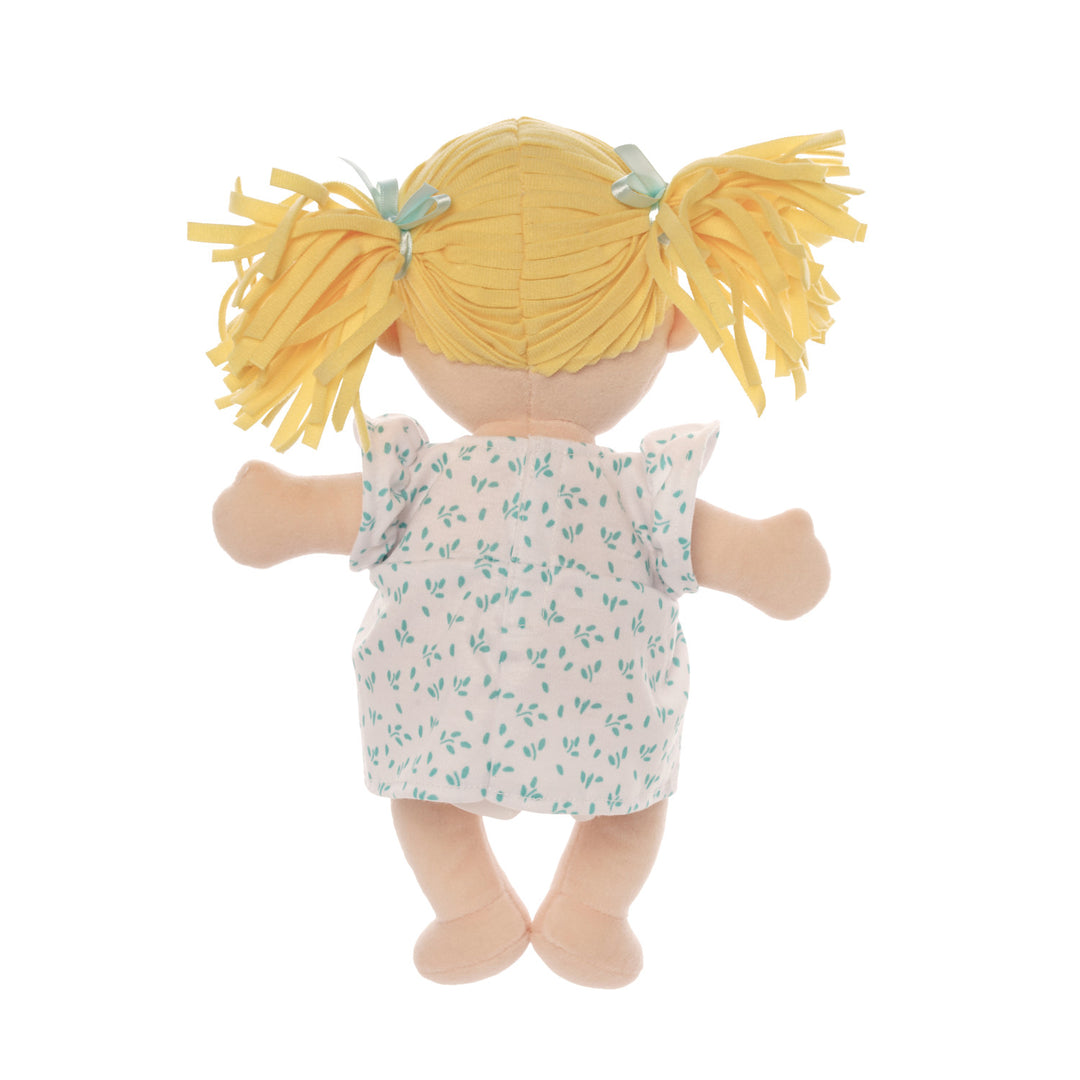 Back side of peach skinned soft doll with blonde pigtails wearing a blue and white dress.