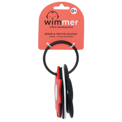 Wimmer Sense & Teethe Shapes™ teether for ages 0+, featuring black, white, and red geometric shapes on a ring, designed for infant development.