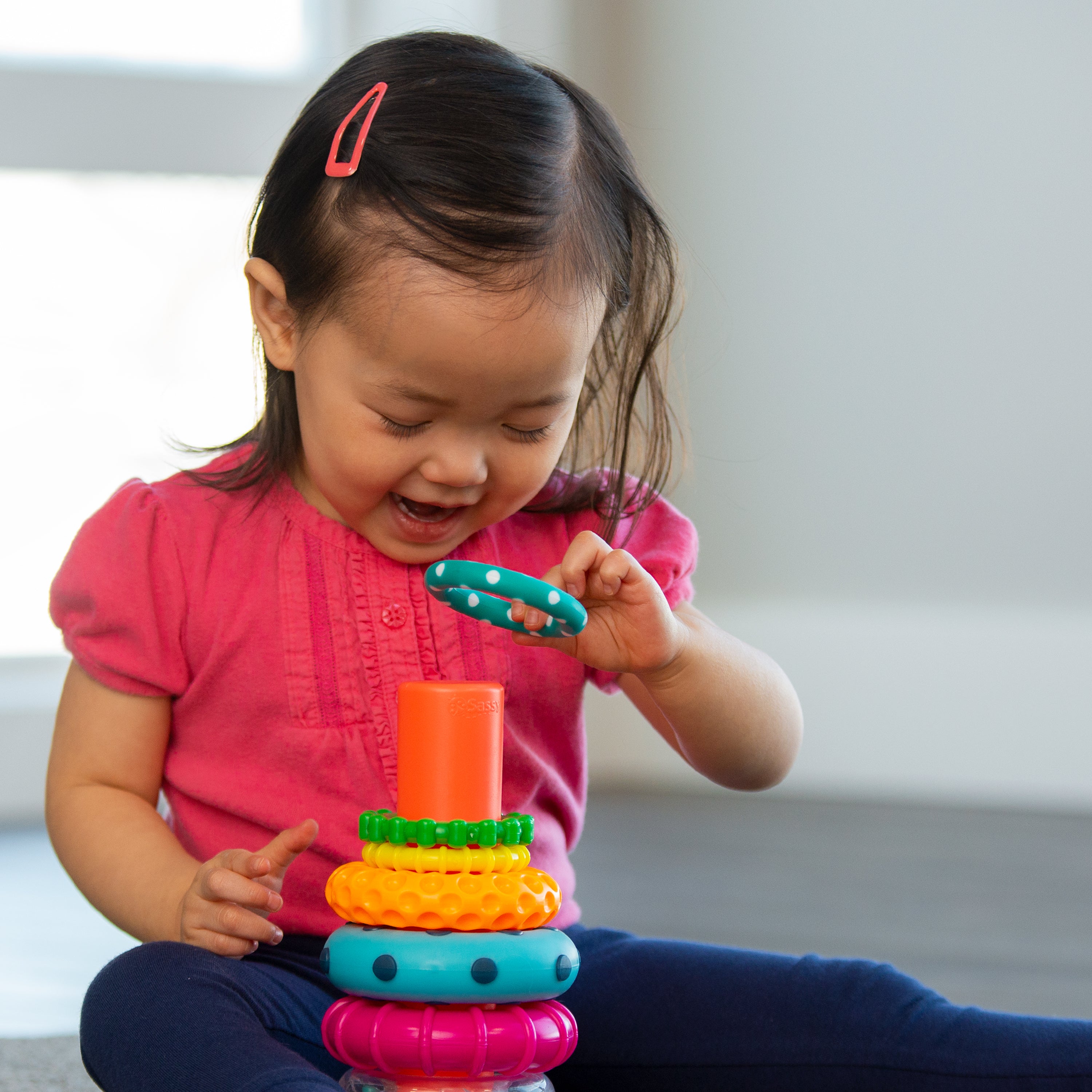 little girl playing with ring  stacker toy