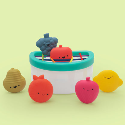Colorful fruit-shaped toys with a bathtub on a light green background