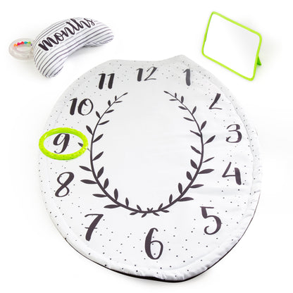 Round milestone mat with numbers and a wreath design, featuring a baby's first birthday hat and mirror on a white background.