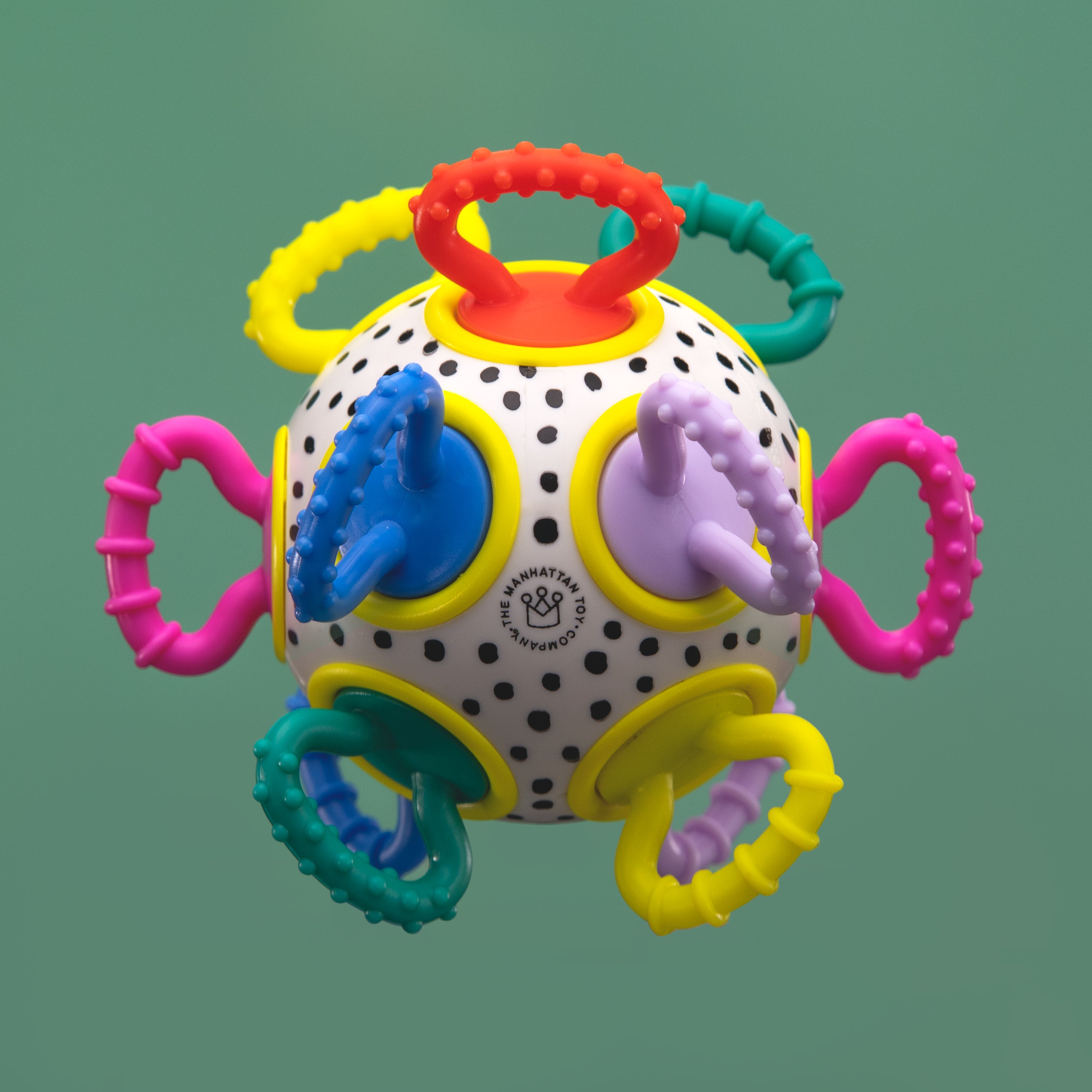 Colorful baby teething ball with multiple handles on a green background