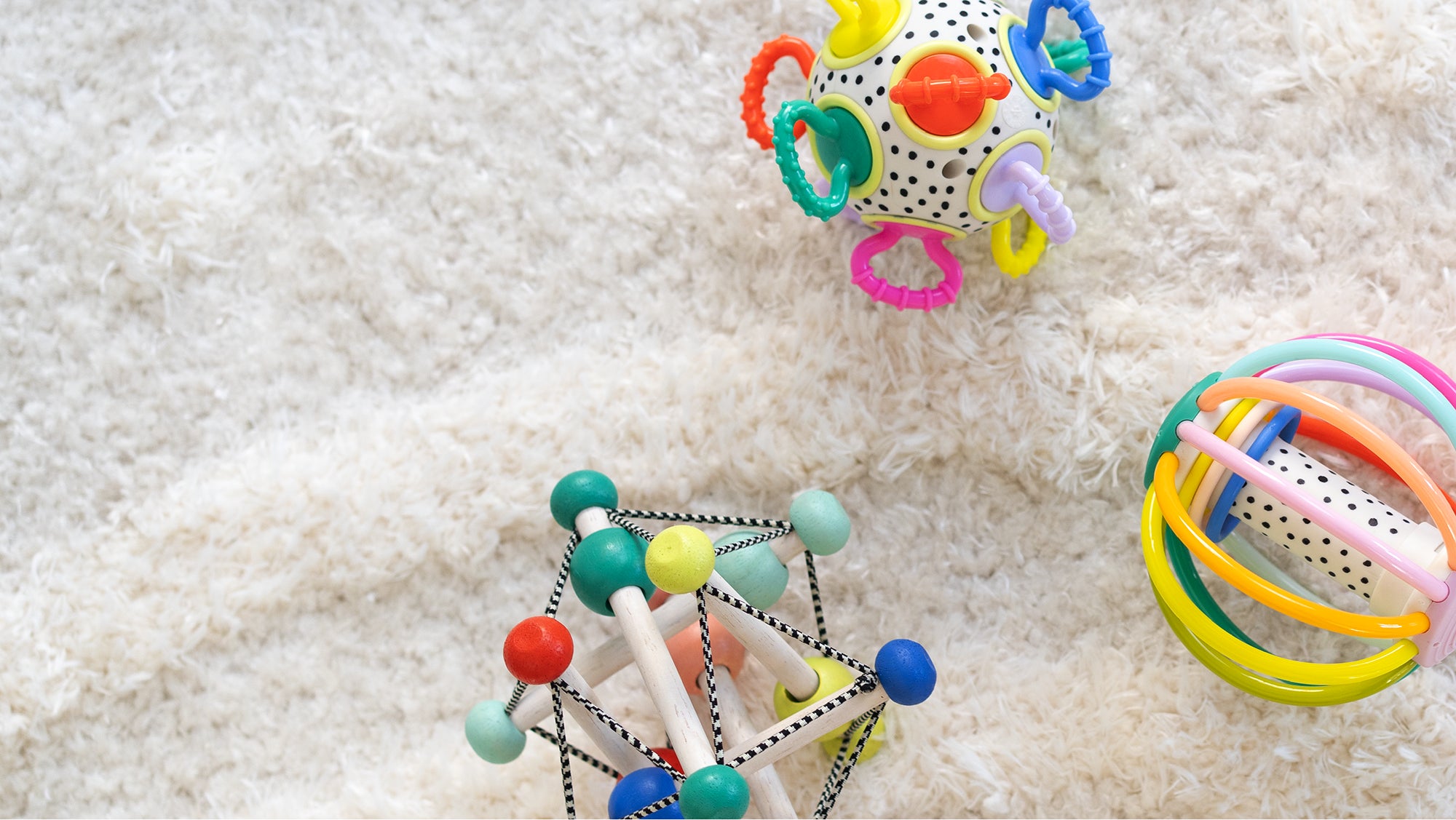 Colorful assortment of toys including blocks, balls, and vehicles on a white background.
