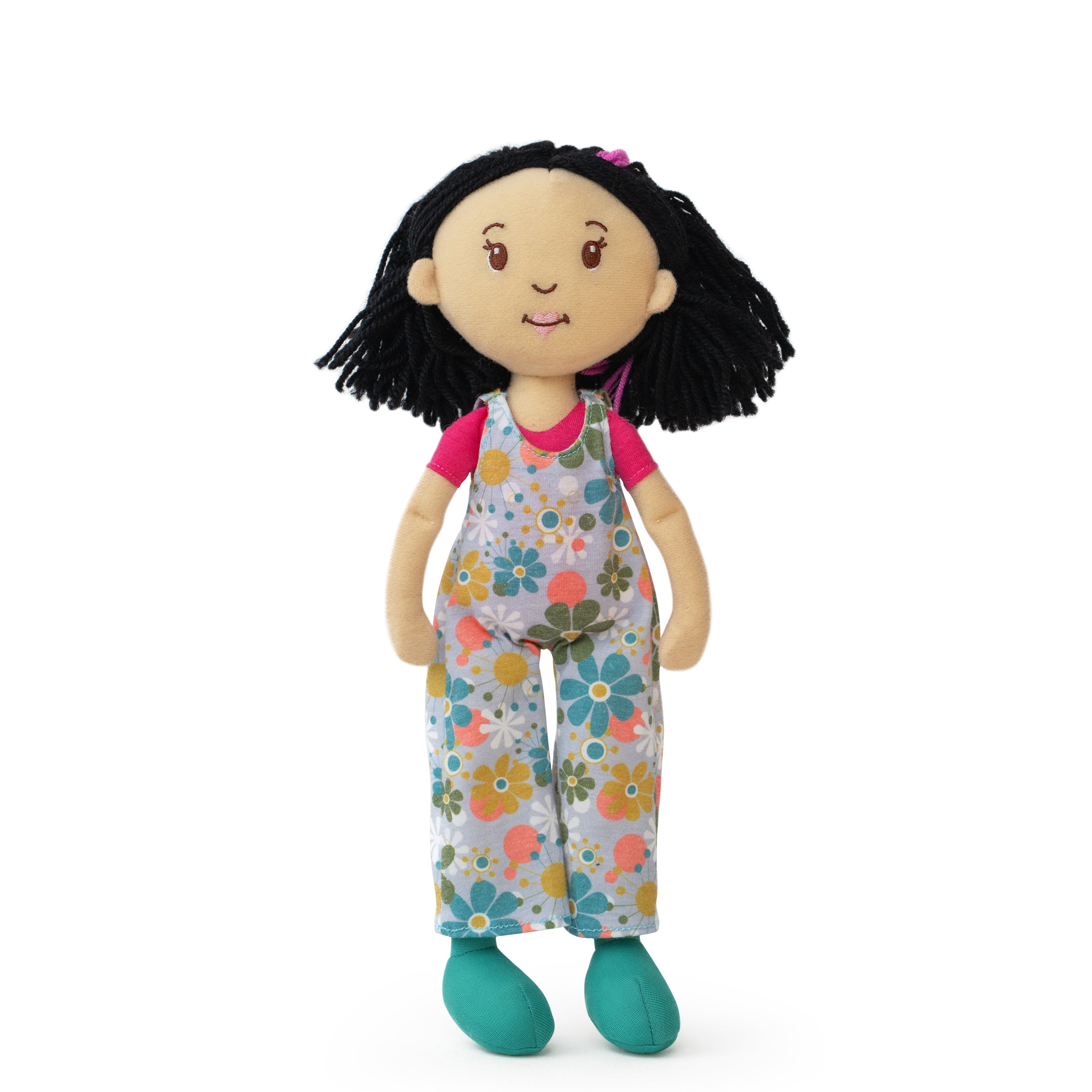 Doll with floral overalls on a white background