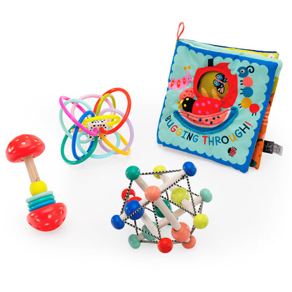 Group visual of a mushroom themed barbell rattle, colorful Winkel teether toy with soft plastic loops, Bugging Through soft sensory book, and wooden skwish teether rattle toy.