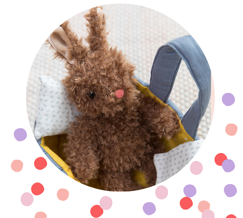 Beau Bunny plush toy sitting in doll carrier