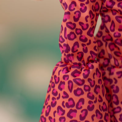 close up of soft doll flare pants that are pink, purple, and orange animal print