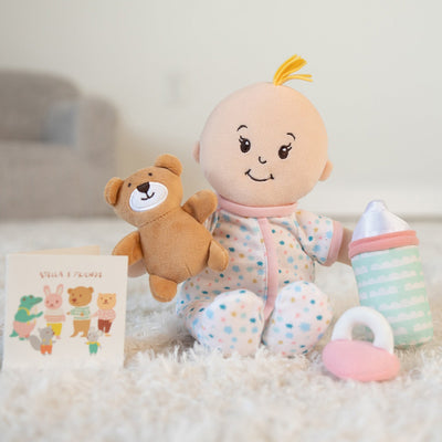 Plush baby doll with a teddy bear, soft bottle, rattle toy, and storybook from Stella & Friends collection.