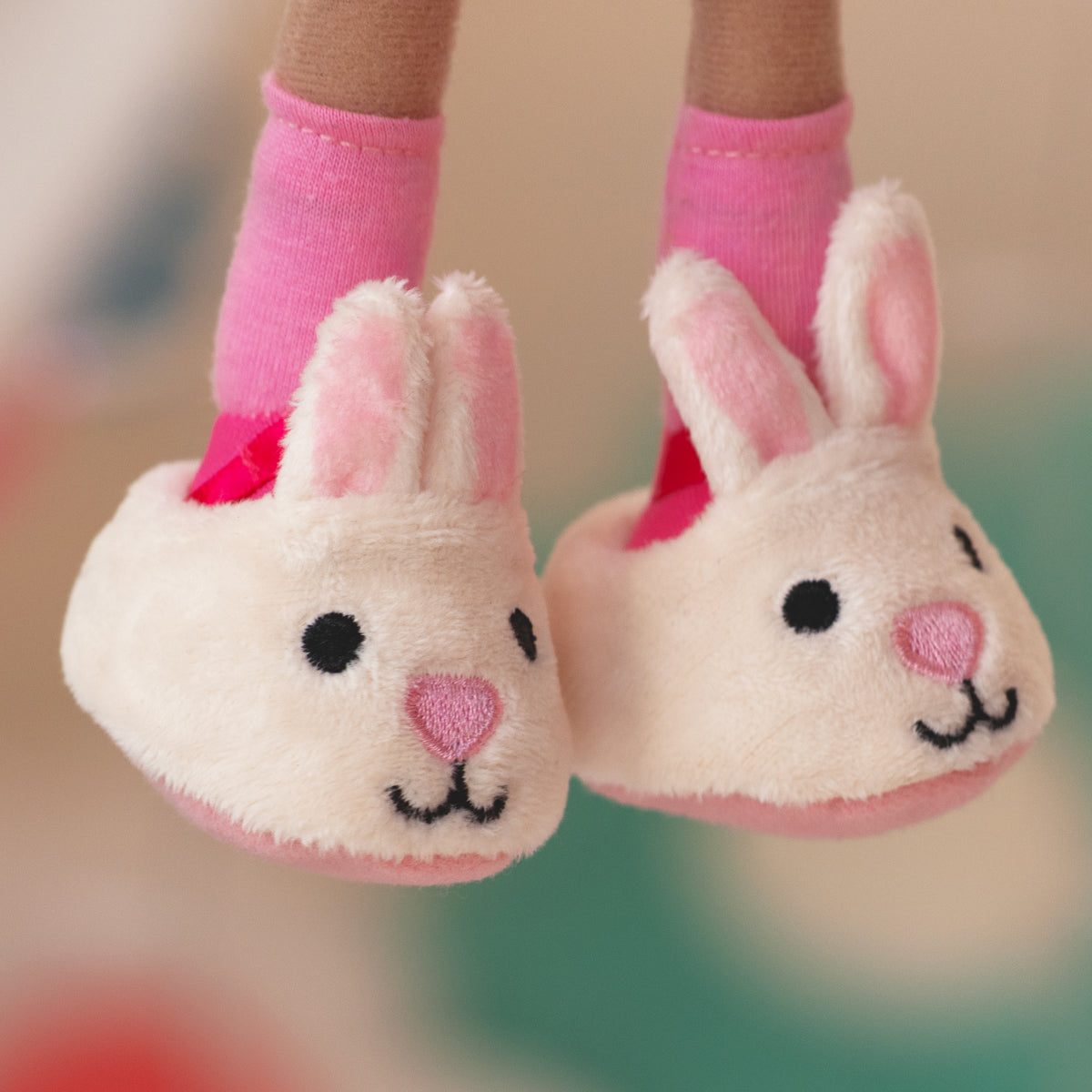 close up of soft doll wearing white bunny slippers