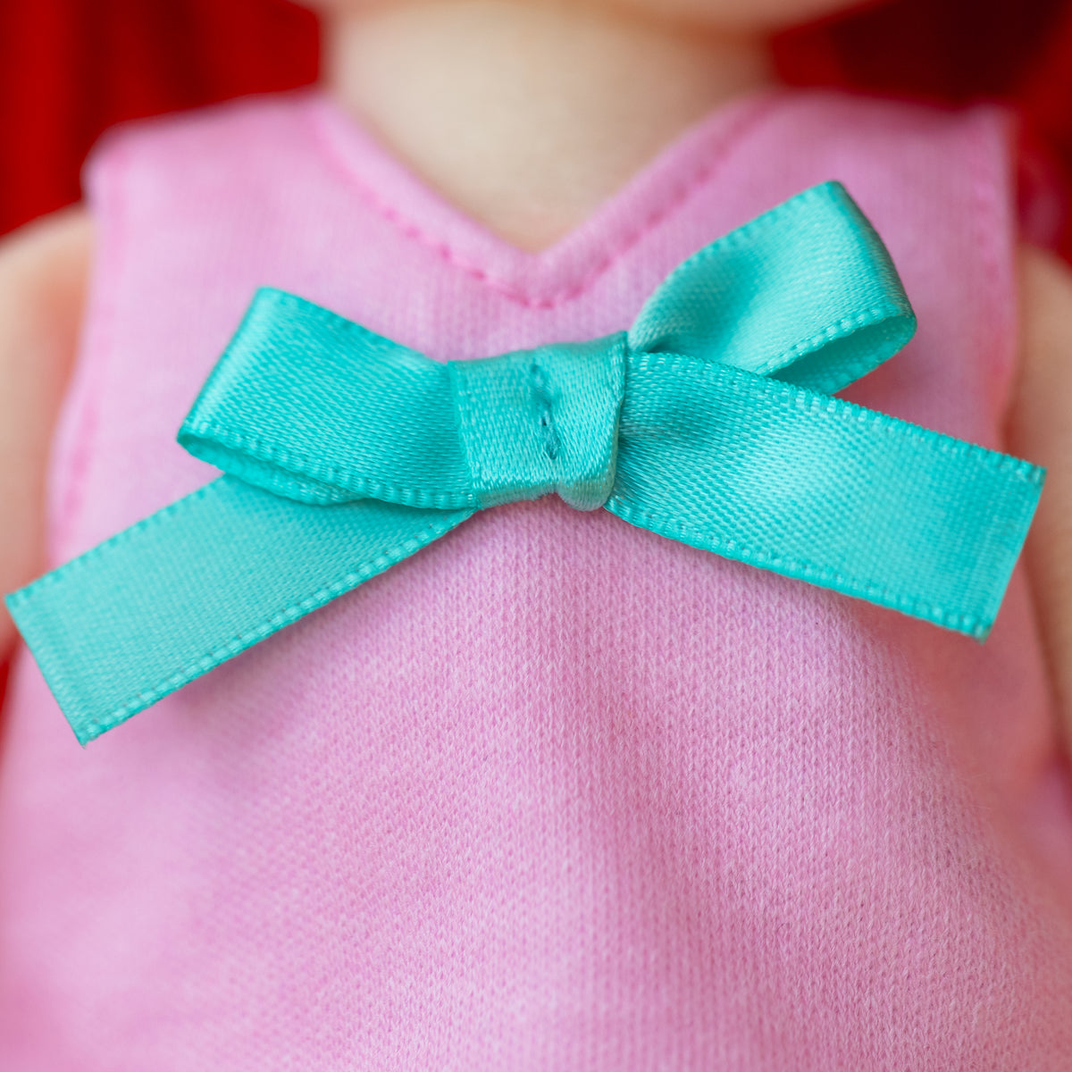 close up of doll shirt with blue bow