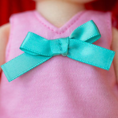 close up of doll shirt with blue bow