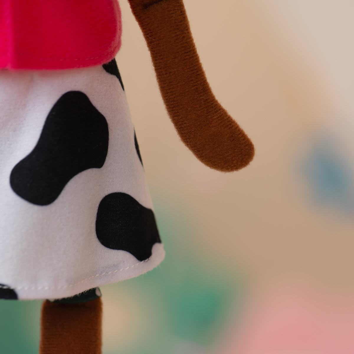 close up of soft doll with cow print skirt