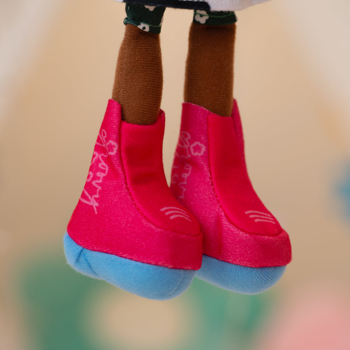 close up of soft doll wearing pink cowgirl boots