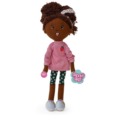 Plush doll with pink shirt and floral pants and hangtags on a white background