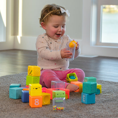Child playing with colorful building blocks on a carpeted floor.