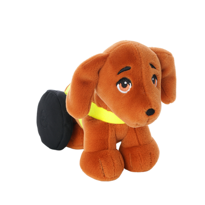 Brown plush dachshund toy with floppy ears, expressive embroidered eyes, and black wheels on its back legs, wearing a bright yellow harness. 45 degree angle