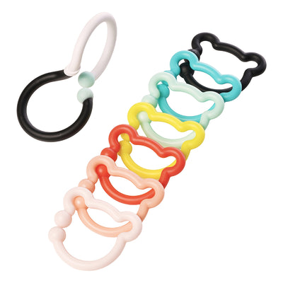 A black and white S-shaped hook next to 7 colorful bear-shaped rings layered on top of each other. 