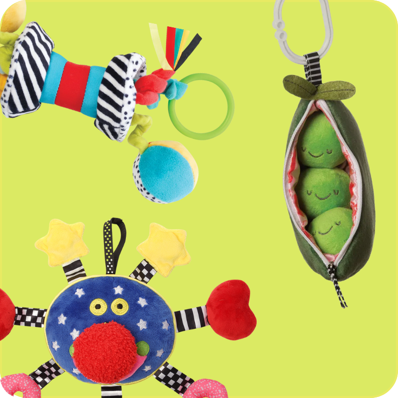 three colorful infant travel toys on a green background