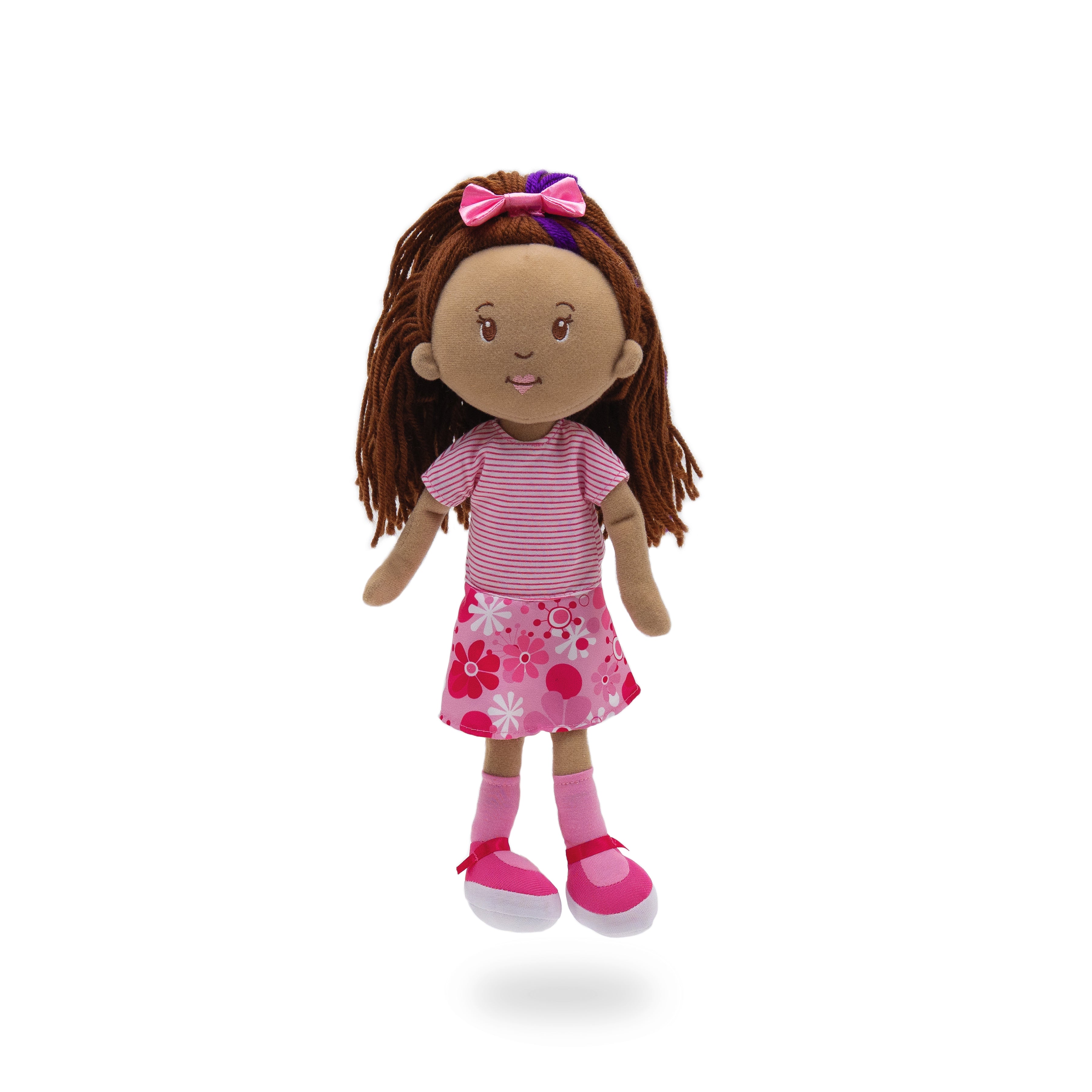 Soft doll wearing pink dress with stripes and floral patterns.