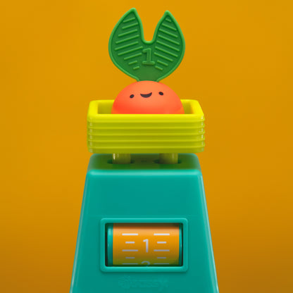 veggie stacker toy with red veggie piece on an orange background.