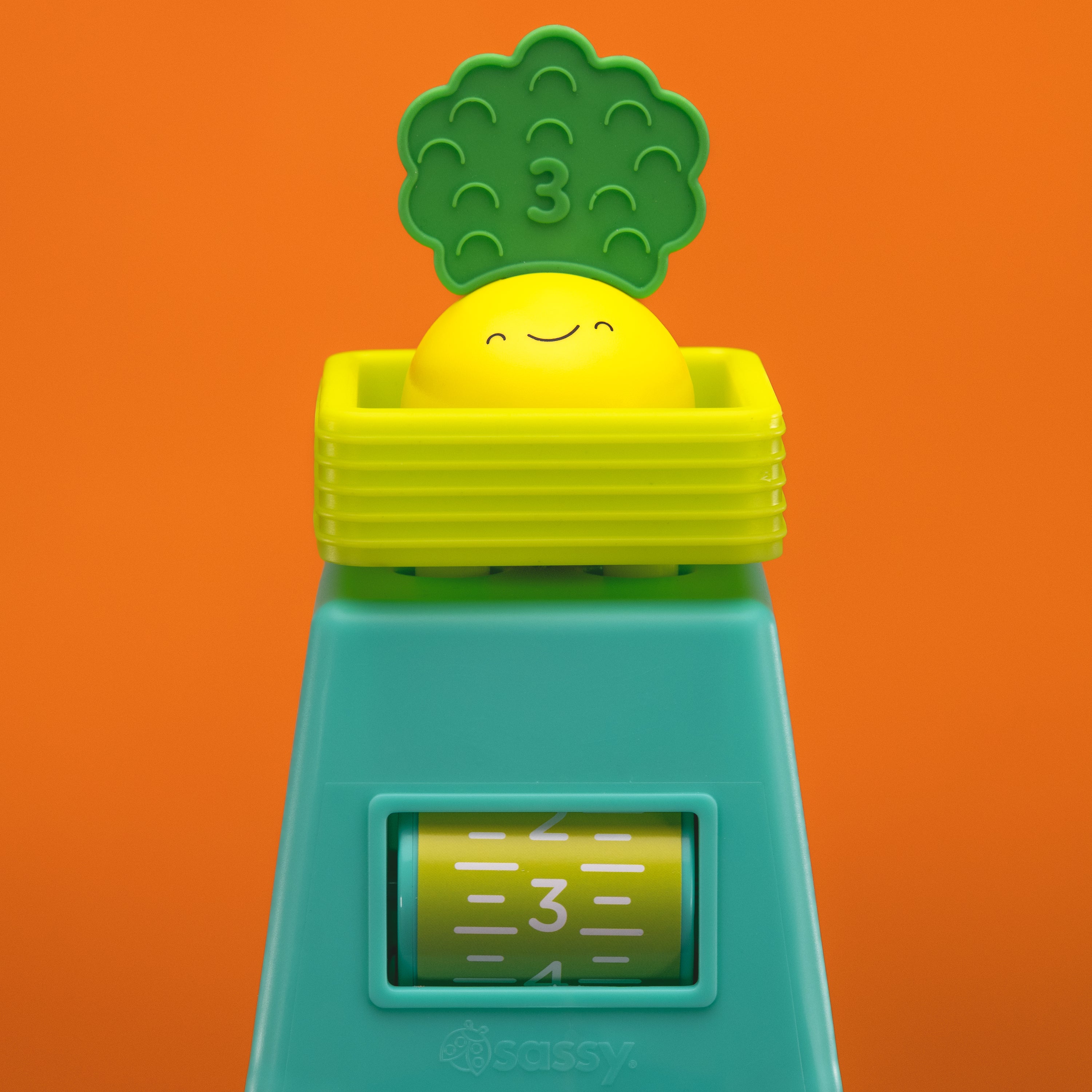 veggie stacker toy with yellow veggie piece on an orange background. 
